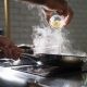 person putting on on frying pan on top of electric stove