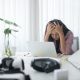 woman holding her head in front of laptop