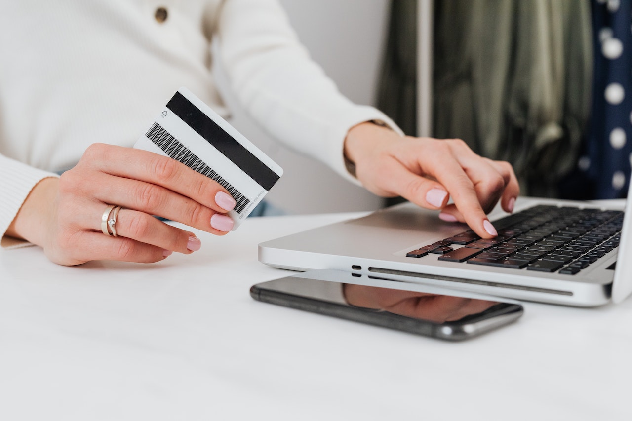 woman holding card and laptop in front