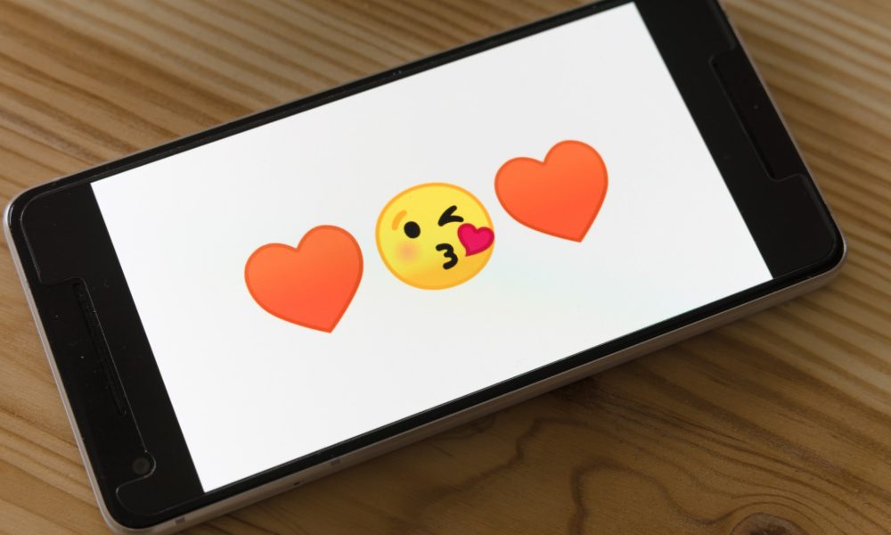 heart kissing emoji on phone screen
