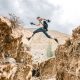 Active man jumping over rocky formations