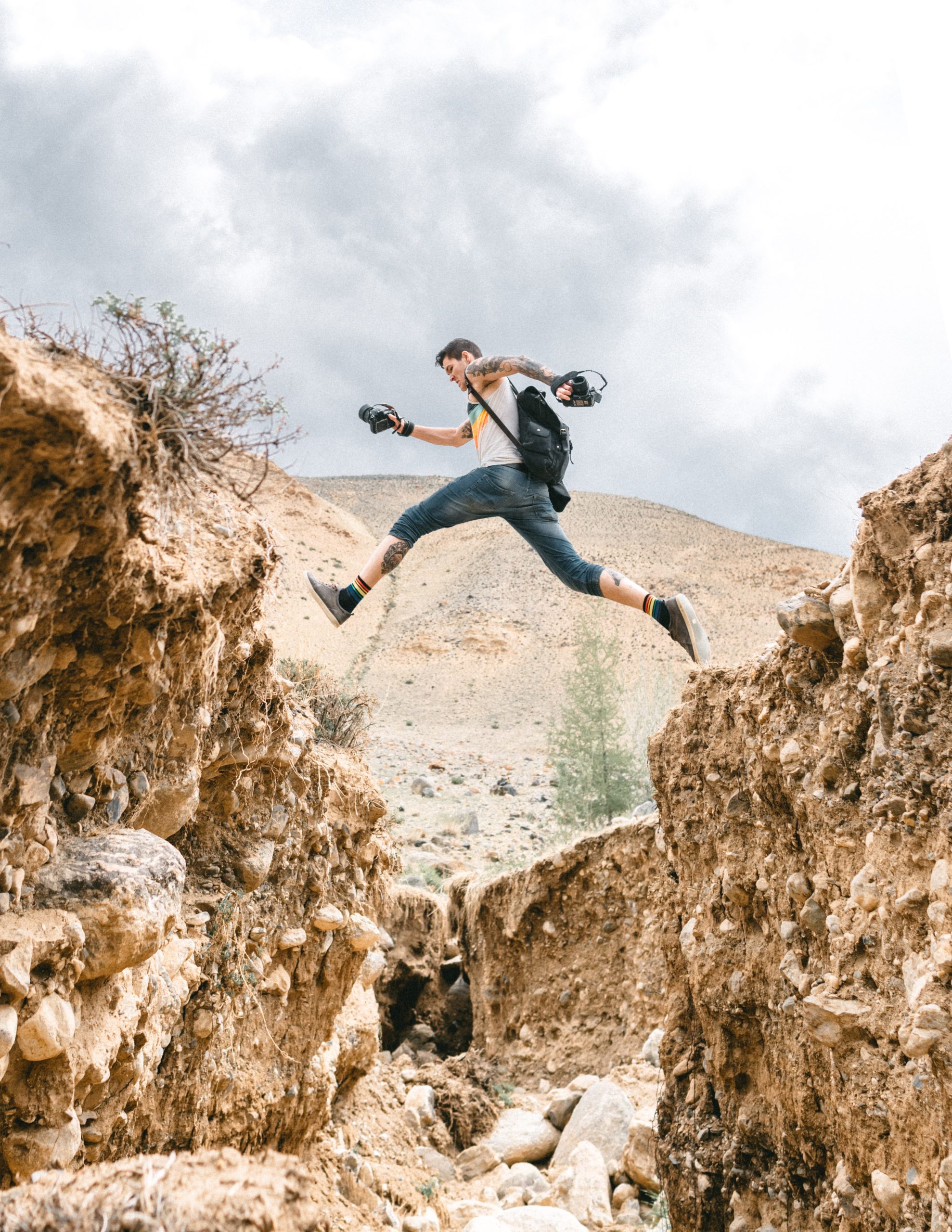 Active man jumping over rocky formations