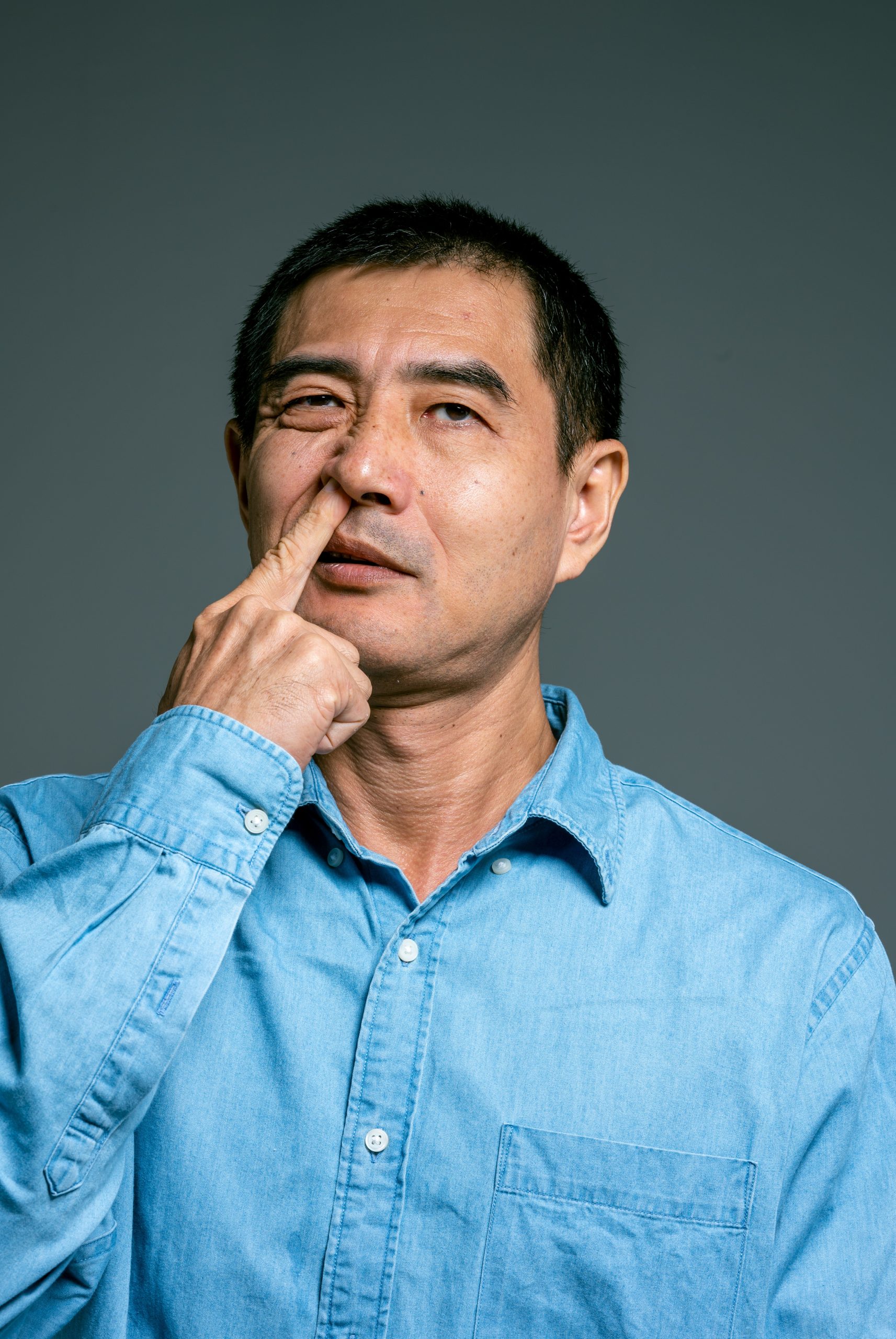 Man in Blue Top Picking Nose