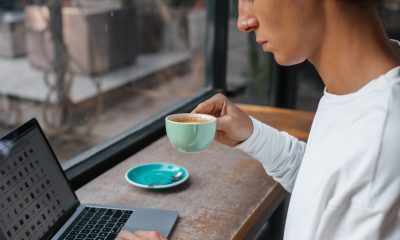 Man Drinking Coffee while Using Laptop