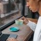 Man Drinking Coffee while Using Laptop