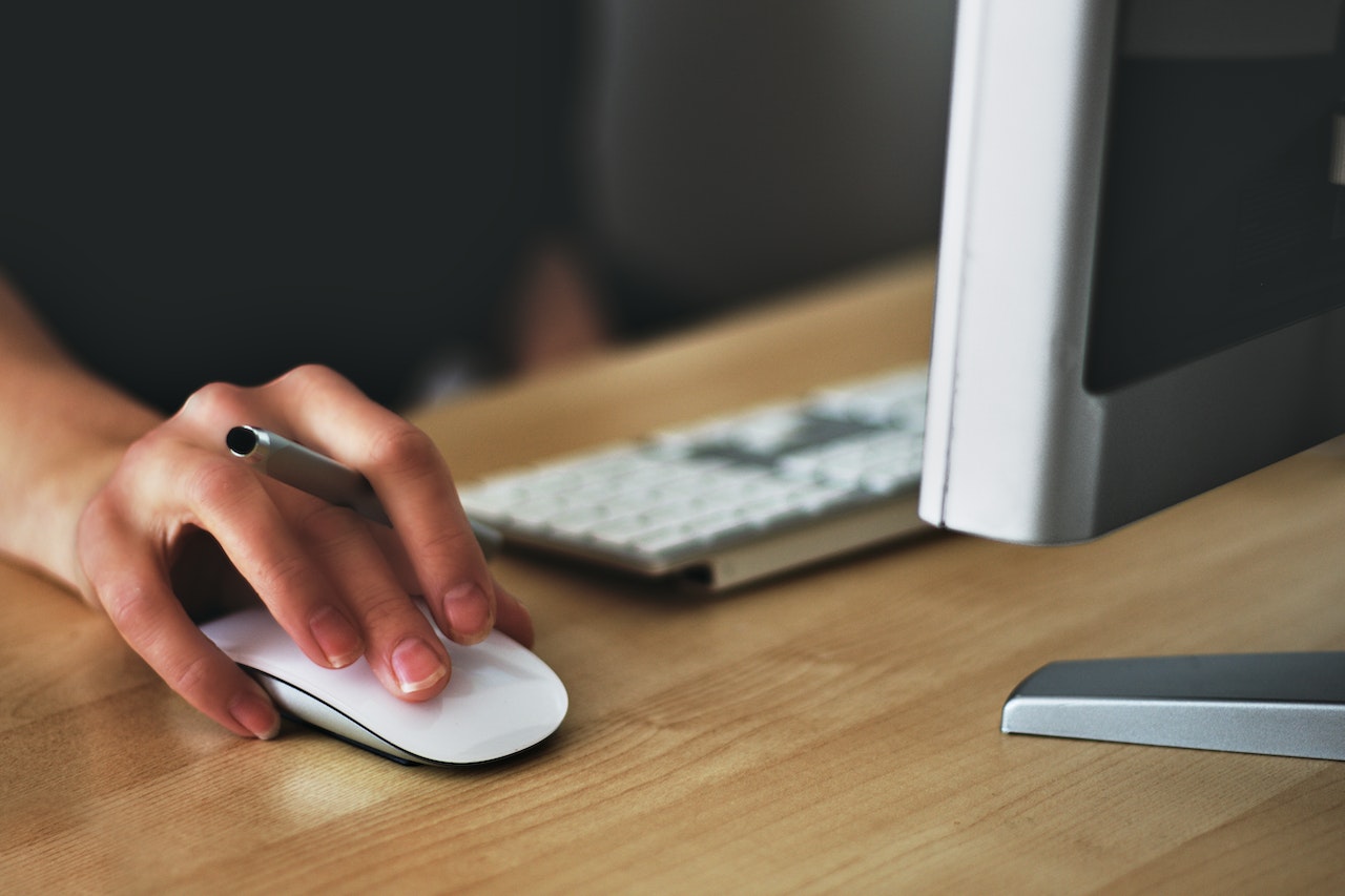 person holding mouse with keyboard