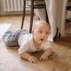 A Baby Crawling On Wooden Floor