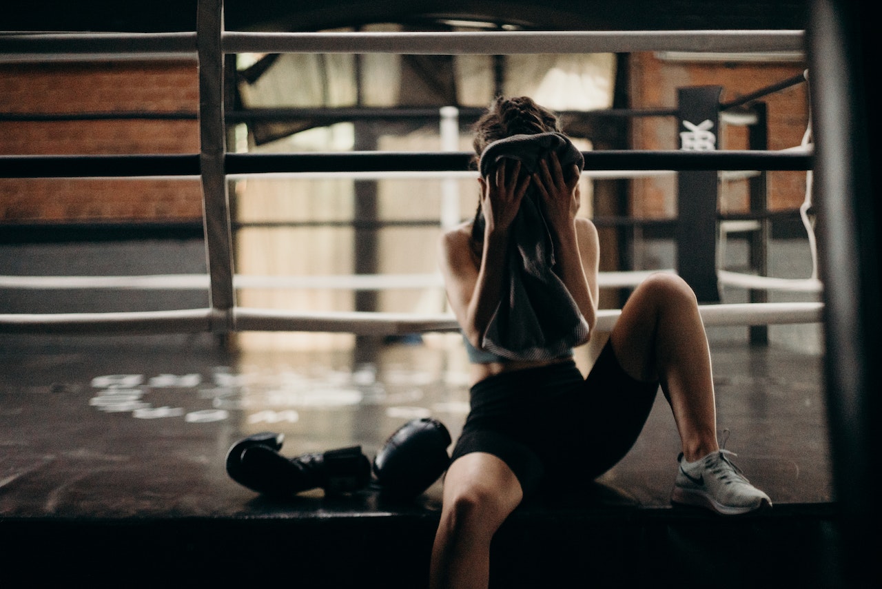woman sitting on boxing ring