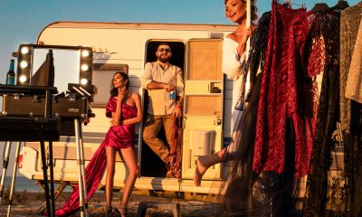 Man with models near trailer and fashionable clothes