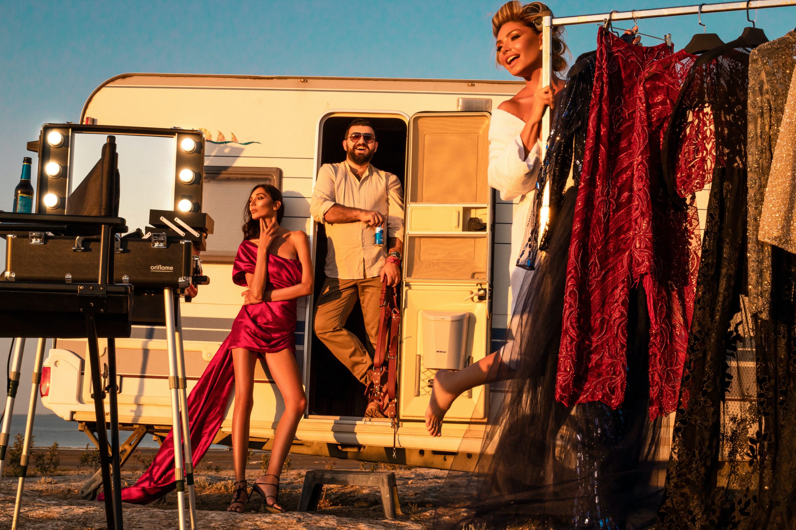 Man with models near trailer and fashionable clothes