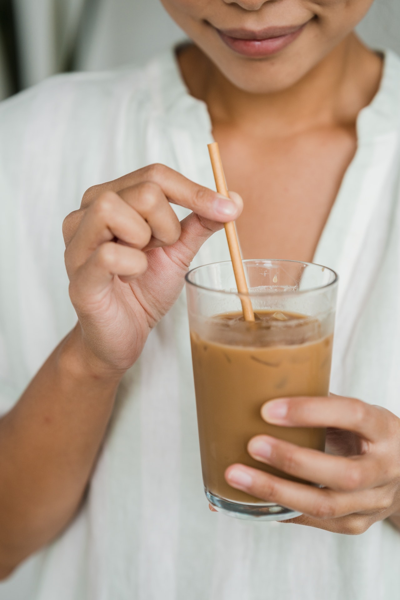 woman holding straw on drink