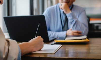 Woman filling job application form in office with boss