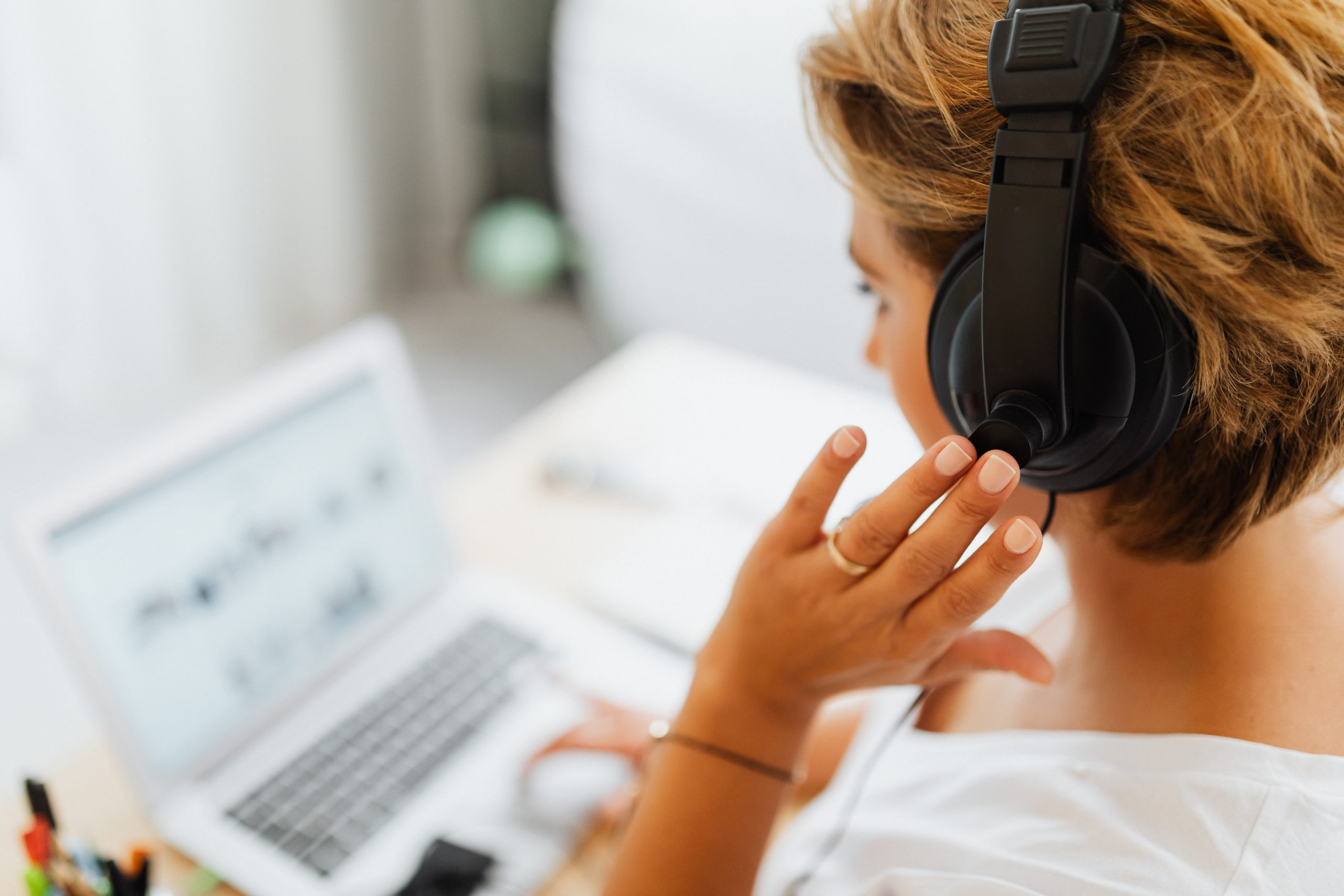 Person in White Shirt Holding Black Headphones