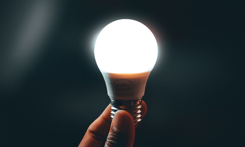 Close-up Photo of an Illuminated Light Bulb held by a Person