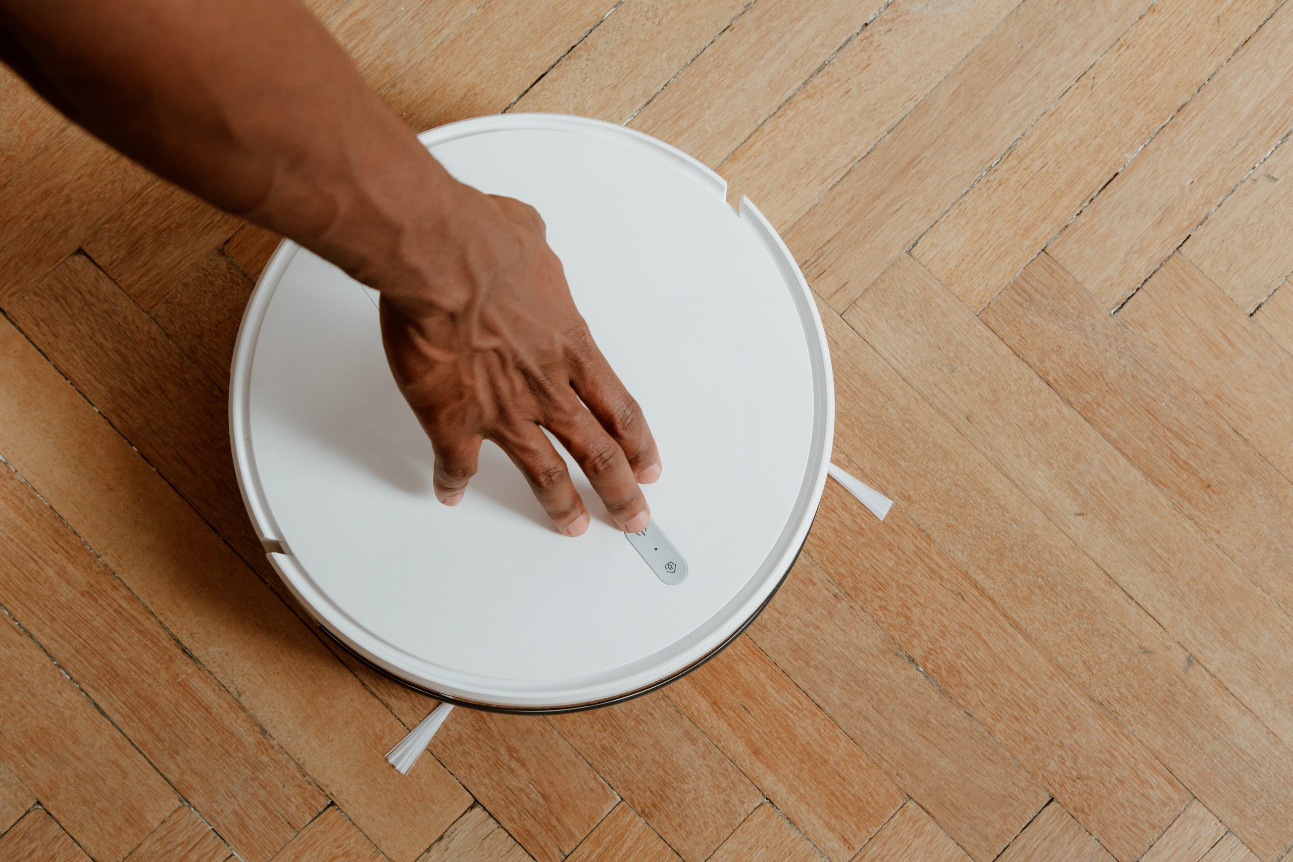 Man Touching Cleaning Robot 