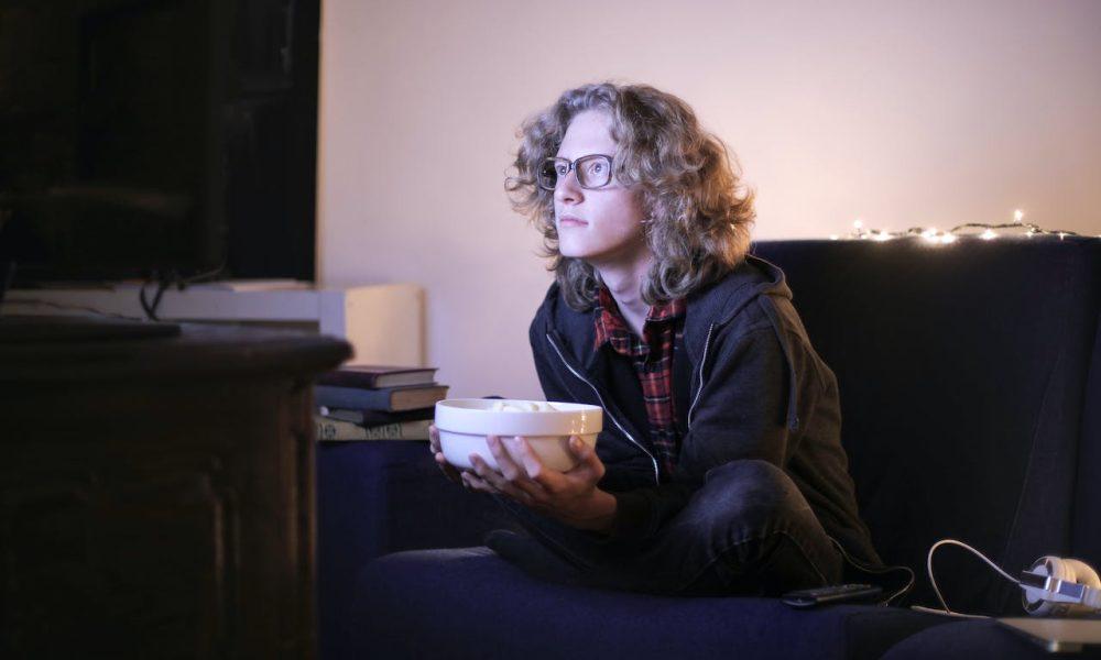 Man with a Bowl of Popcorn Watching TV at Home