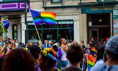 People Gathered Near Building Holding LGBT Flag at Daytime
