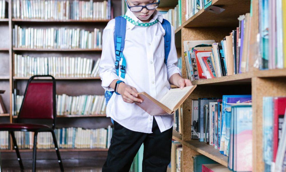 Boy in White Long Sleeve Shirt in the Library