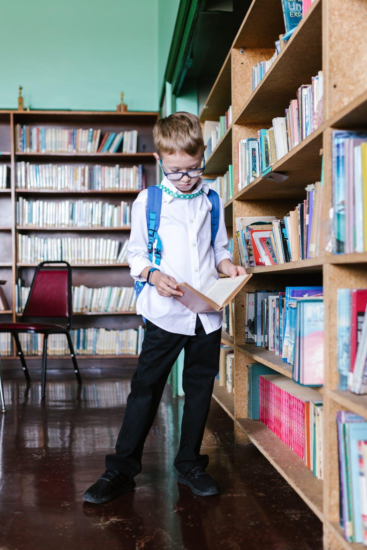 Boy in White Long Sleeve Shirt in the Library