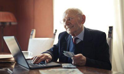 old man holding money while working