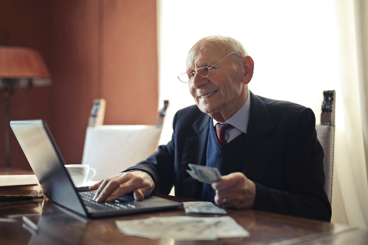 old man holding money while working