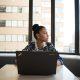 Woman Sits in Front of Black Laptop Computer