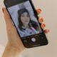 Close-up of a Smartphone Screen Displaying a Woman Taking a Selfie