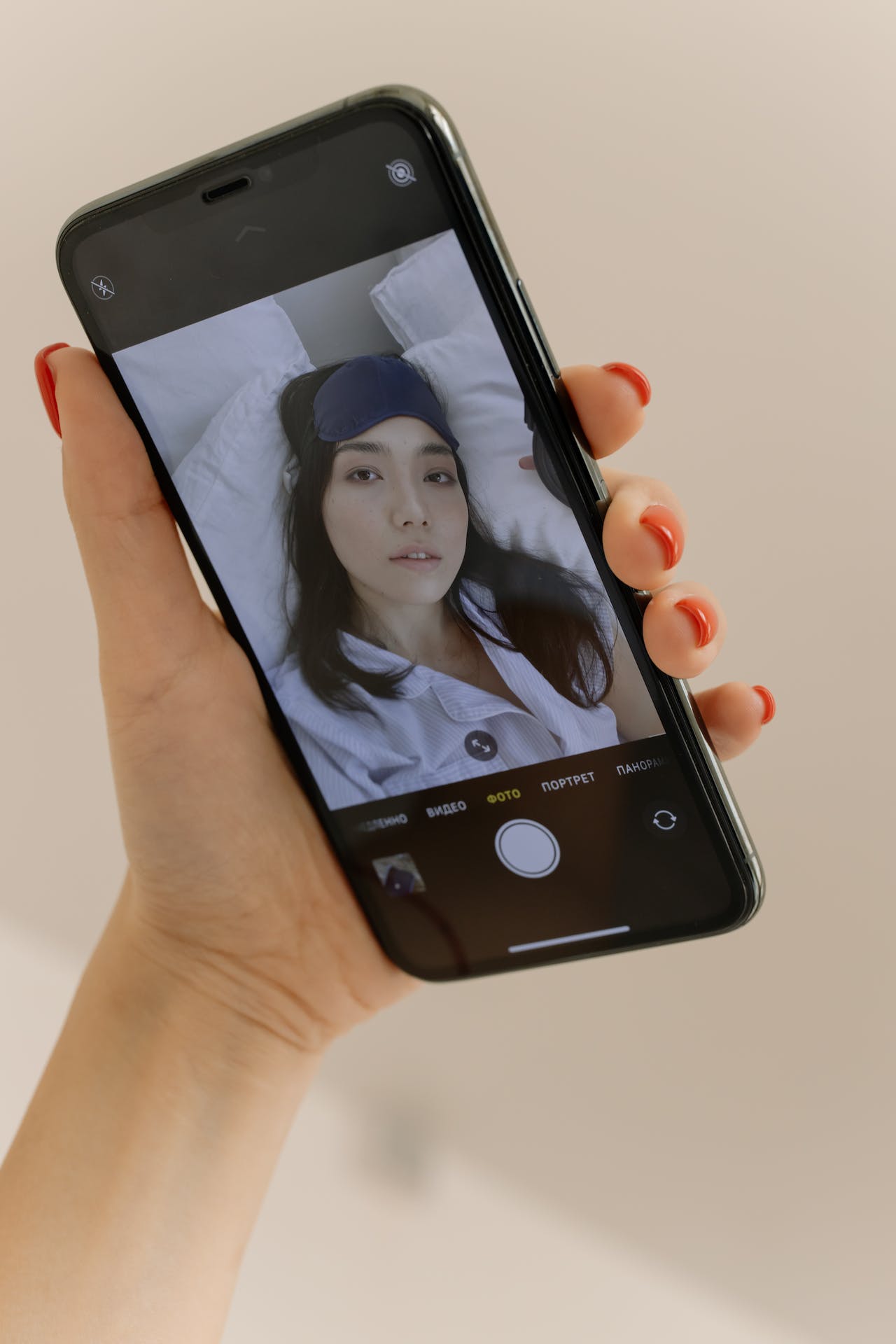 Close-up of a Smartphone Screen Displaying a Woman Taking a Selfie