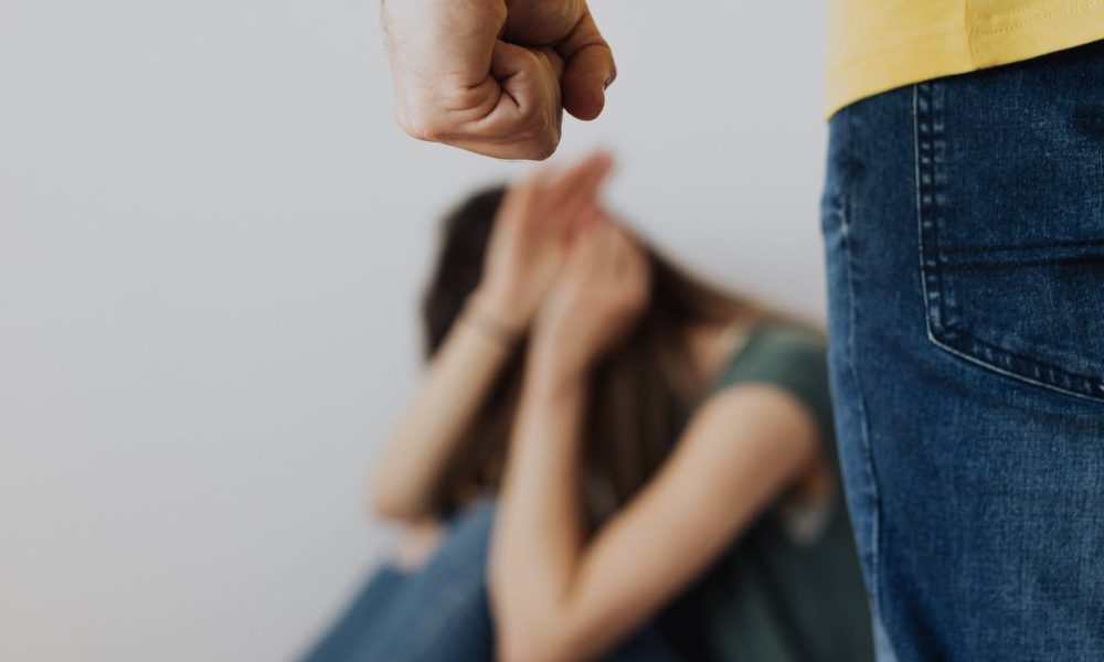 Man in Yellow Shirt and Blue Denim Jeans Clenching Fist Near a Woman in Green Top