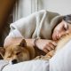 woman sleeping with dog on bed