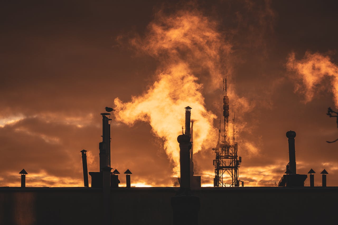 Silhouette of Factory Under Cloudy Sky