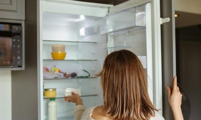 woman putting food inside fridge