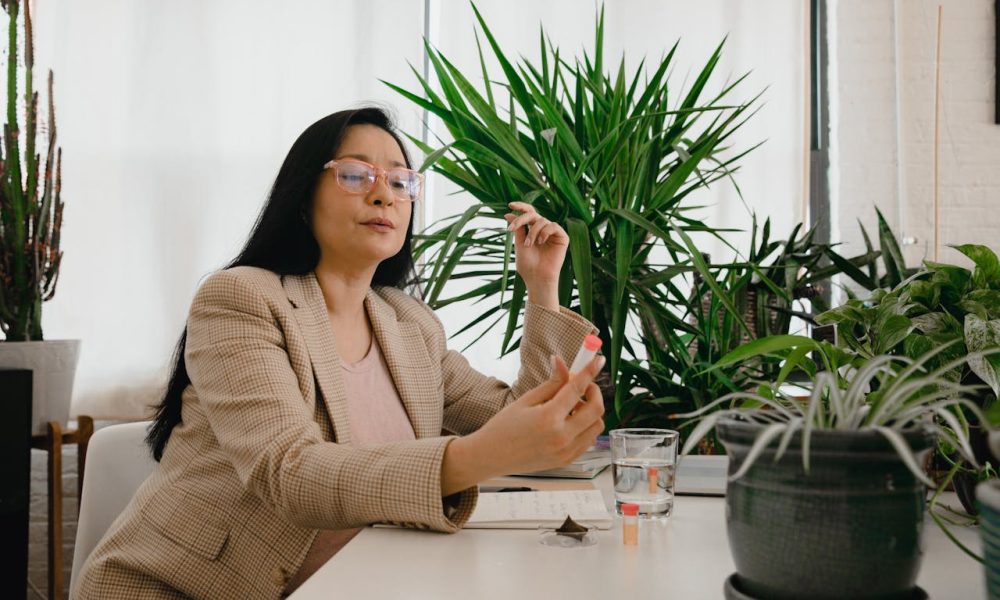 Woman in Beige Plaid Blazer Sitting and Holding a Plant Medicine