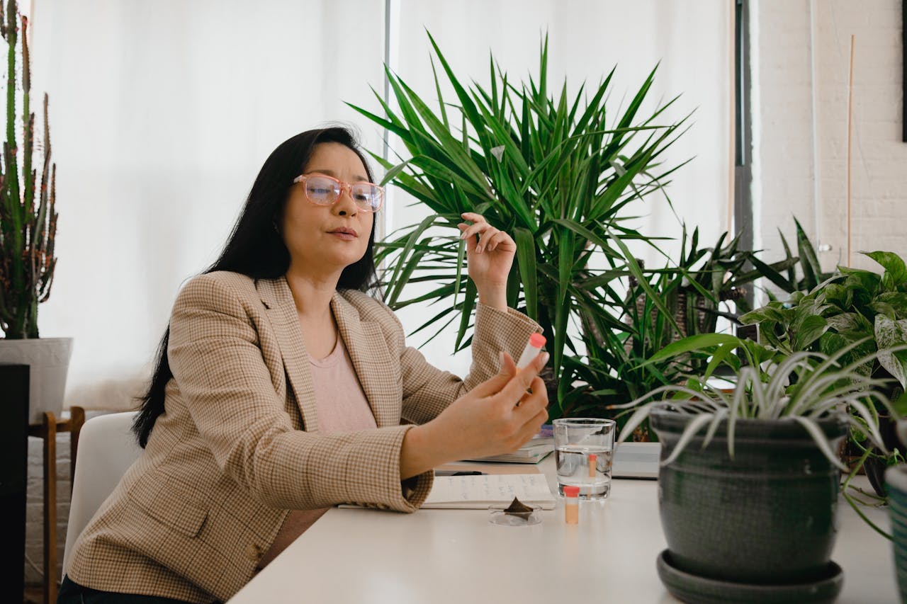 Woman in Beige Plaid Blazer Sitting and Holding a Plant Medicine