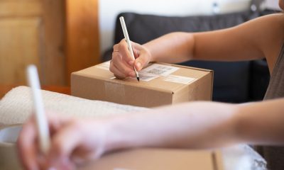 Person Writing on Brown Cardboard Box