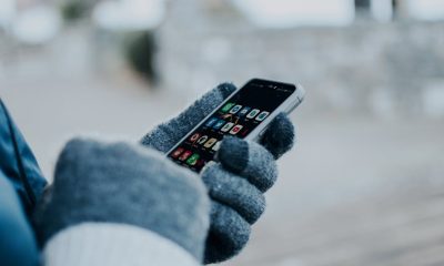 hand with gloves holding phone