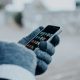 hand with gloves holding phone