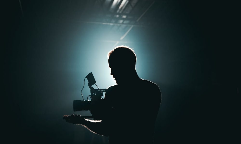 Silhouette of a director standing in front of a camera.