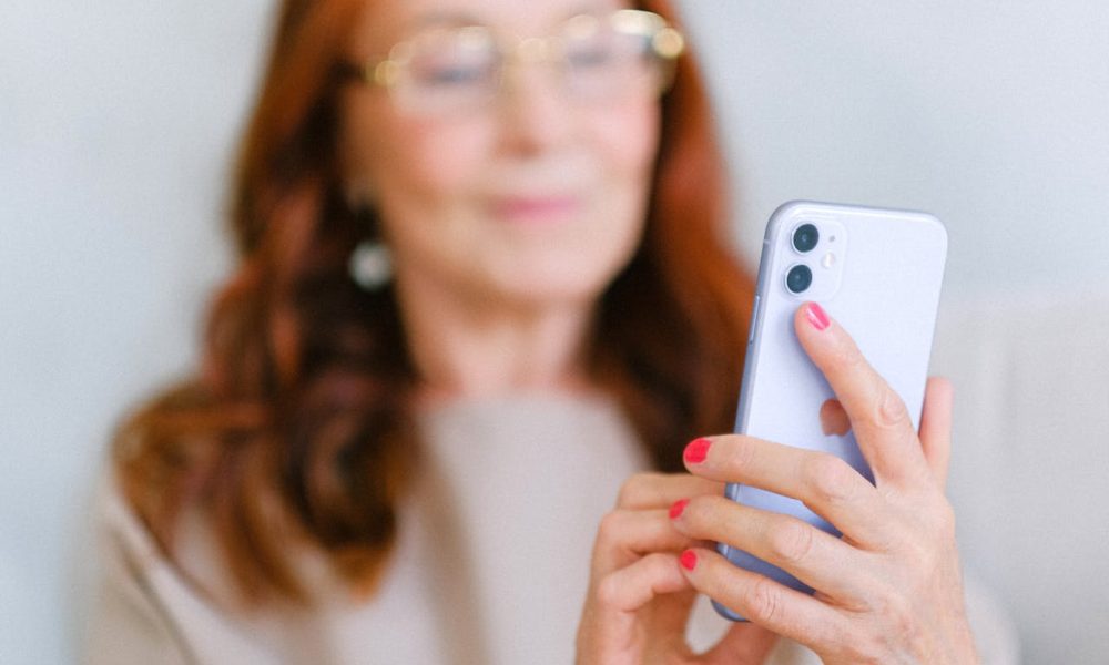Elderly woman messaging on modern smartphone