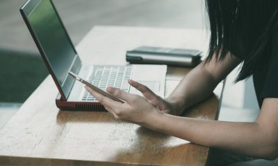 woman using phone and laptop