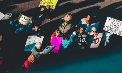 Photo of People Standing With Signage on Street.