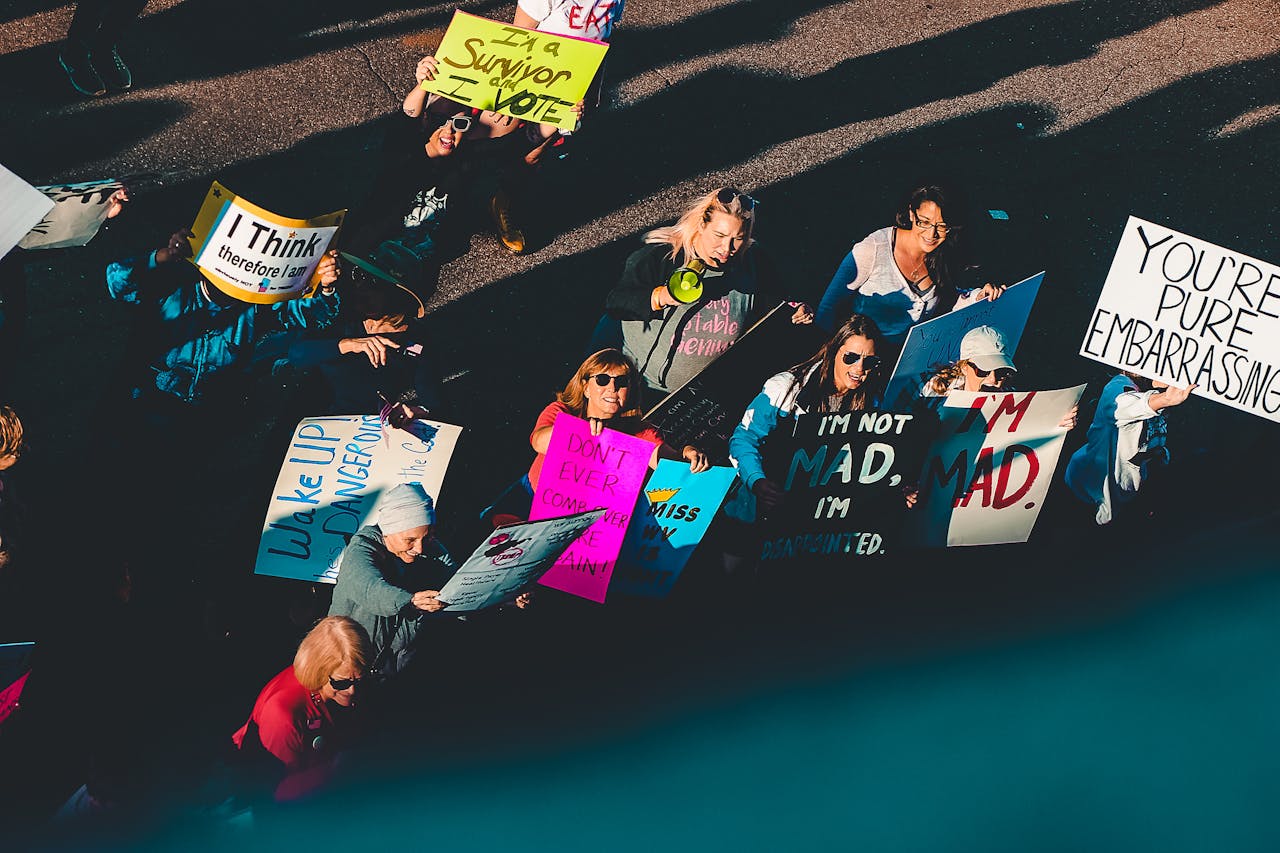 Photo of People Standing With Signage on Street.